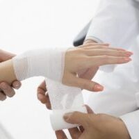 Doctors bandage to women of wrist